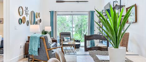 Un salon moderne avec un canapé, des fauteuils, une table basse et une plante en pot.