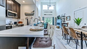 Una cocina moderna con armarios oscuros, un microondas y una isla grande con asientos.