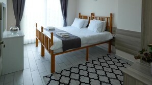 Une chambre à coucher comprenant un lit, une table de chevet, une commode, un miroir et un tapis à motifs.