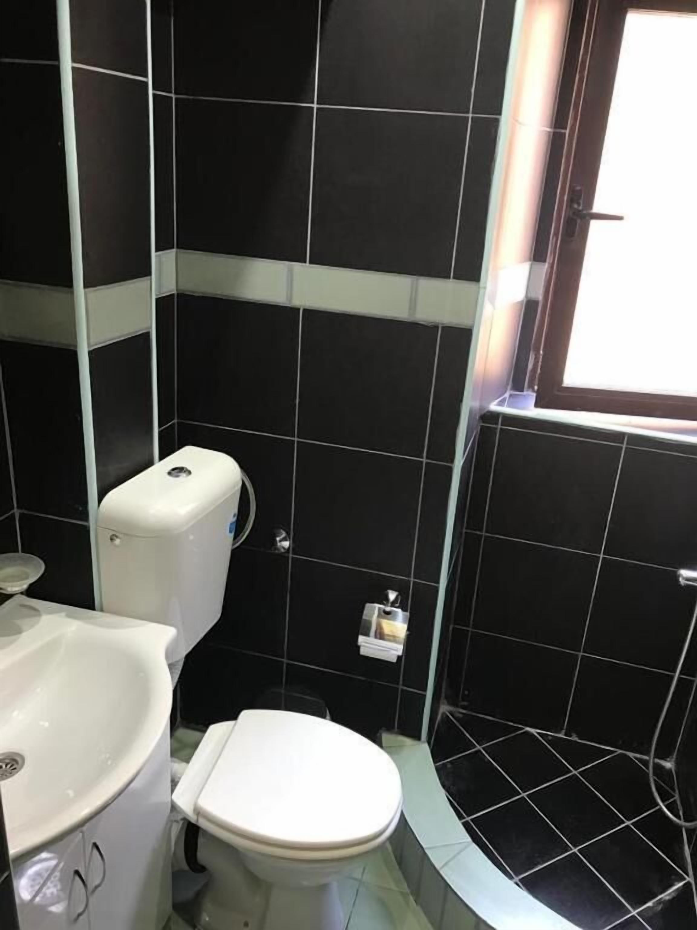 Un bagno piccolo con il water, un lavandino e una finestra.