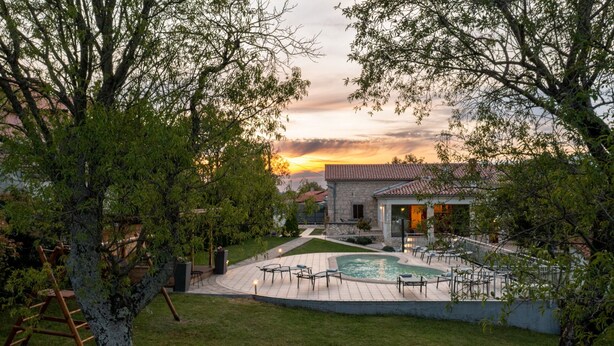 A stone house with a swimming pool, surrounded by trees and a well-maintained lawn. - Holiday Home Flores with Pool (Labin)