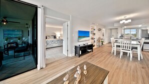 Een ruime woonkamer met een grote televisie, een eettafel en een keuken.