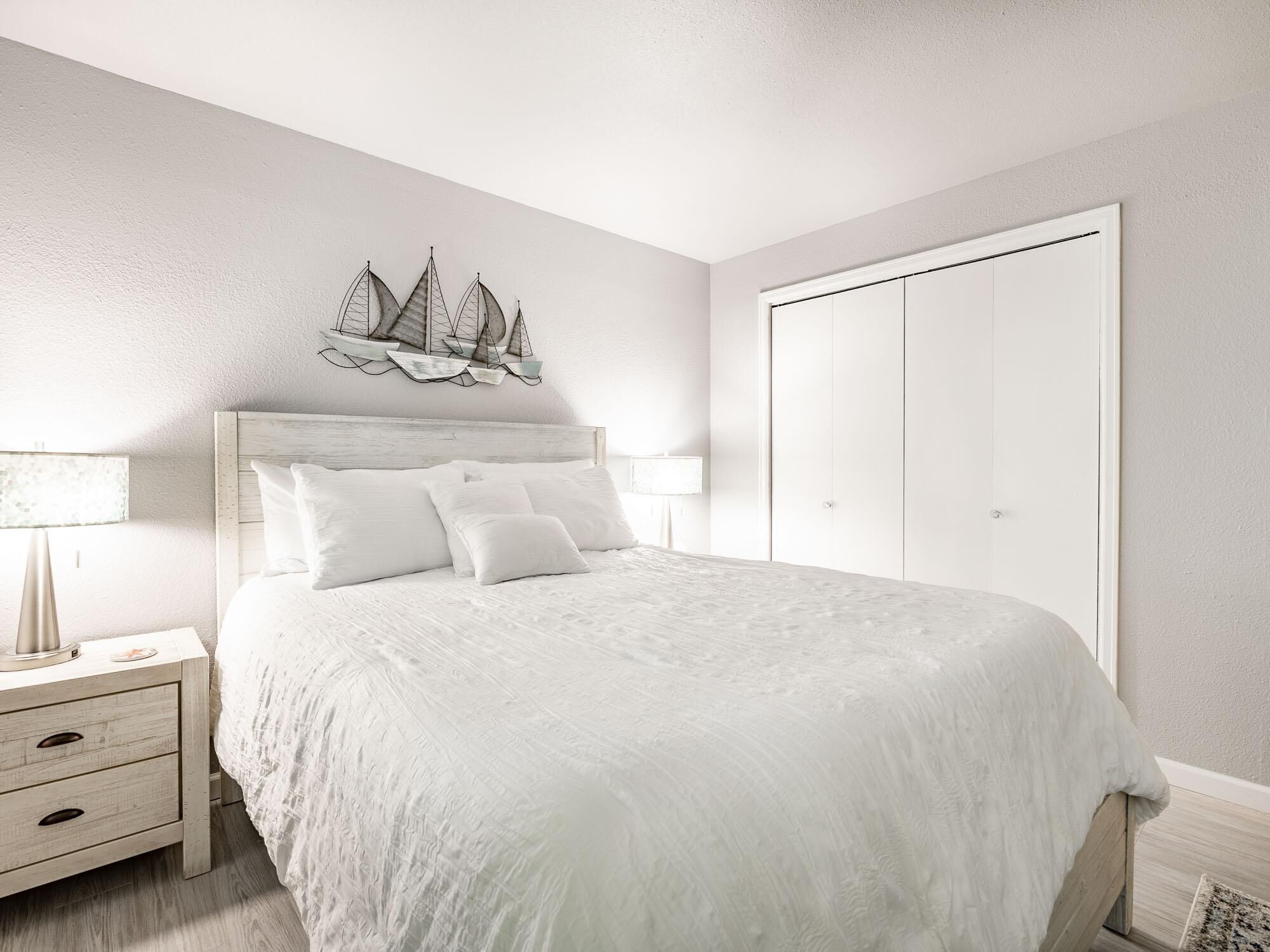A bedroom with a bed, nightstands, a dresser, and a wardrobe.