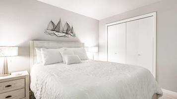 A bedroom with a bed, nightstands, a dresser, and a wardrobe.