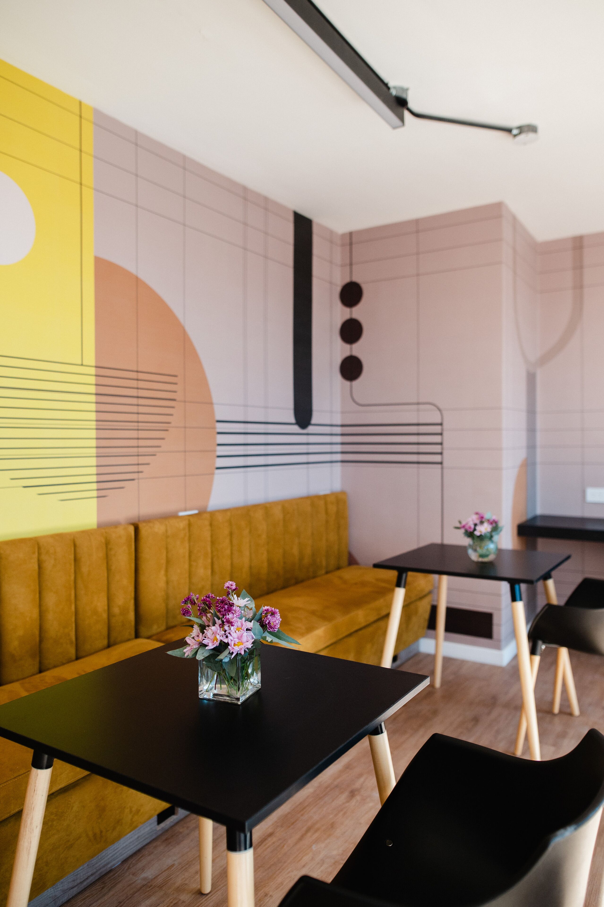 A modern interior with a black table, a yellow sofa, and a black chair.