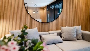 A modern living room with a circular mirror, wooden panel walls, and a sofa with cushions. - Top Rentals Palermo Hollywood (Buenos Aires)