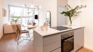 A modern kitchen with a central island, a dining area with a table and chairs, and a large window providing a view of the city. - Top Rentals Palermo Hollywood (Buenos Aires)