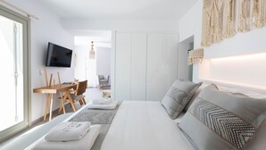 Een moderne slaapkamer met een bed, een bank, een bureau en een televisie.