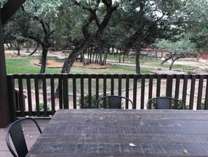 Relax on the patio surrounded by lush greenery and a serene atmosphere.