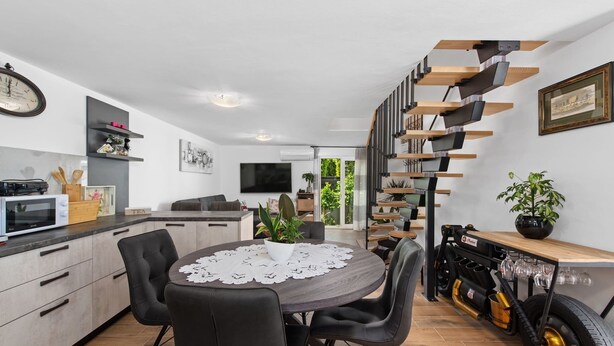 A modern kitchen with a dining area, a staircase, and a unique engine display.