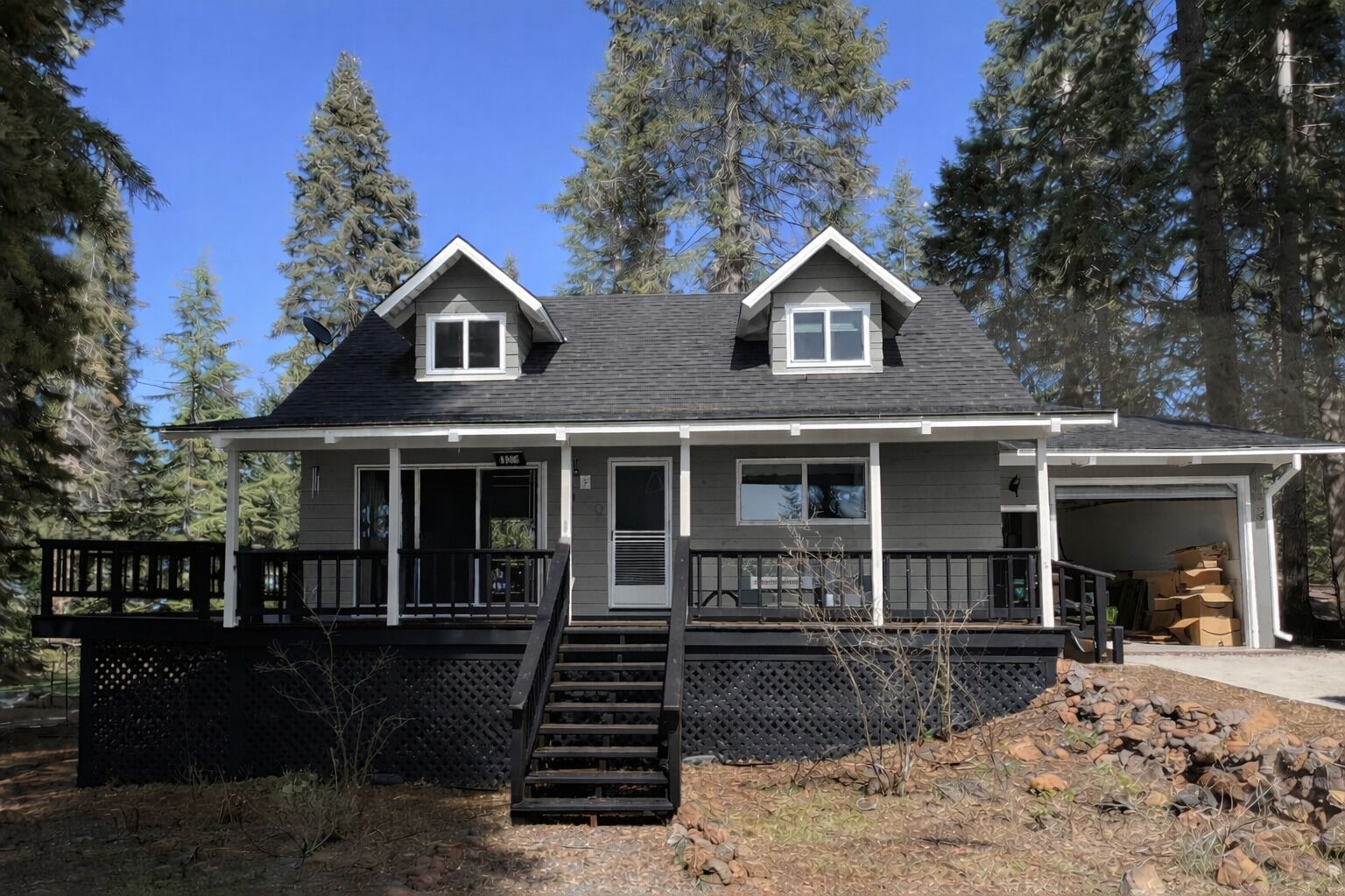 A two-story house with a front porch, a garage, and a staircase leading to the entrance.