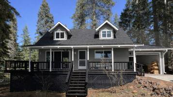 A two-story house with a front porch, a garage, and a staircase leading to the entrance.