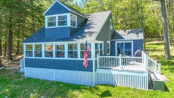 Relax on the front deck with a view of the surrounding trees and lush green landscape.