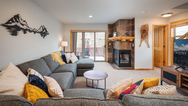 A living room with a sofa, a small round table, and a fireplace.