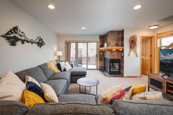 A living room with a sofa, a small round table, and a fireplace.