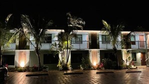 A multi-story hotel with a paved courtyard, palm trees, and a waterfall feature. - 400 South - Unit E (Cocoa Beach)