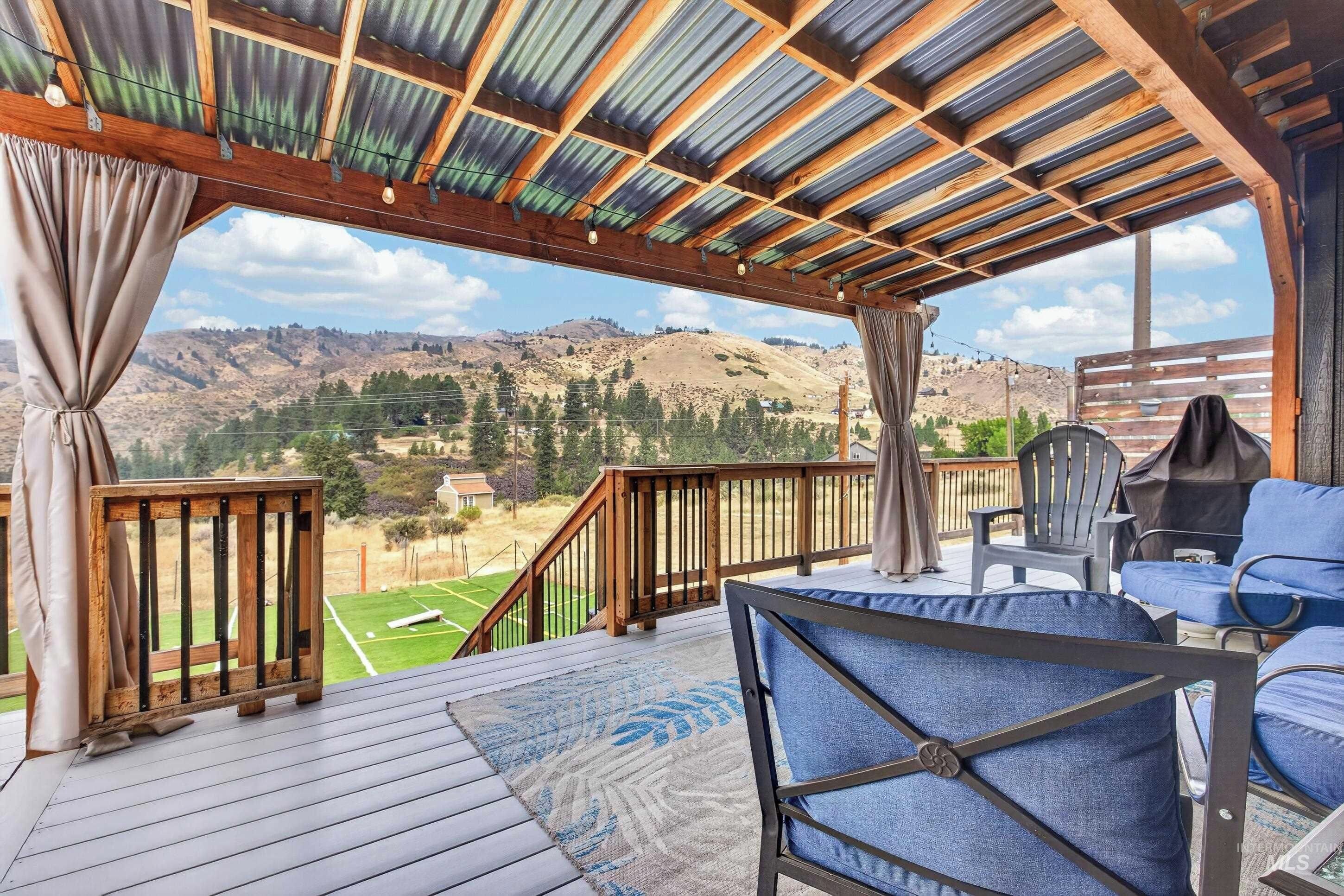 Una terraza techada con vistas a un paisaje montañoso.