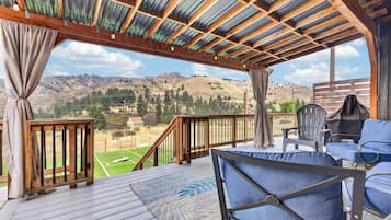 Una terraza techada con vistas a un paisaje montañoso.