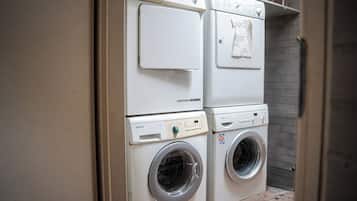 A laundry room with two stacked washing machines and a dryer.