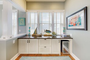 Enjoy a bright and airy space with a large window, white cabinetry, and a framed artwork.