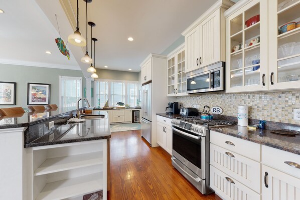 Enjoy cooking in this well-equipped kitchen with a central island, sink, and stainless steel appliances.