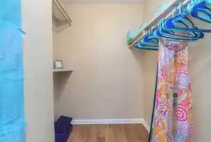 Cozy retreat with a single bed, wall-mounted shelf, and colorful curtain for added privacy.