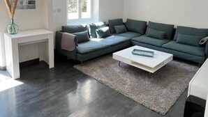 A modern living room with a sectional sofa, a coffee table, and a white console table. - Villa Avec Piscine en Plein Coeur de Bastia (Bastia)