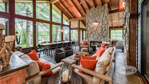 A spacious indoor area with wooden beams, stone walls, and large windows offering views of the outdoors.