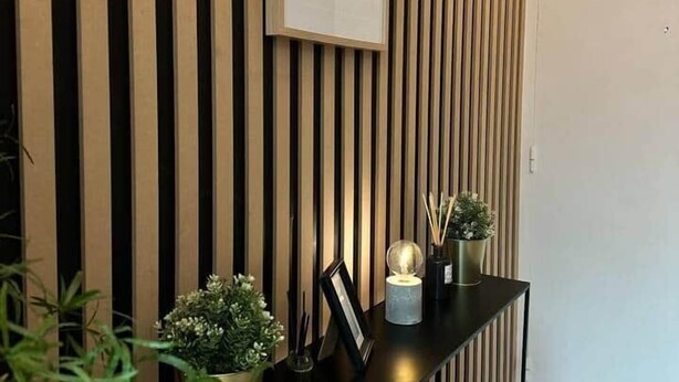 Una mesa de recepción con un cartel enmarcado, una planta en maceta y una pequeña mesa con un globo terráqueo y velas.