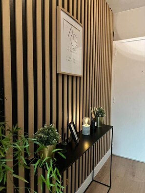 A reception desk with a framed sign, a potted plant, and a small table with a globe and candles. - Le Loft du Chapitre Nouveau Look en centre ville (Saint-Brieuc)
