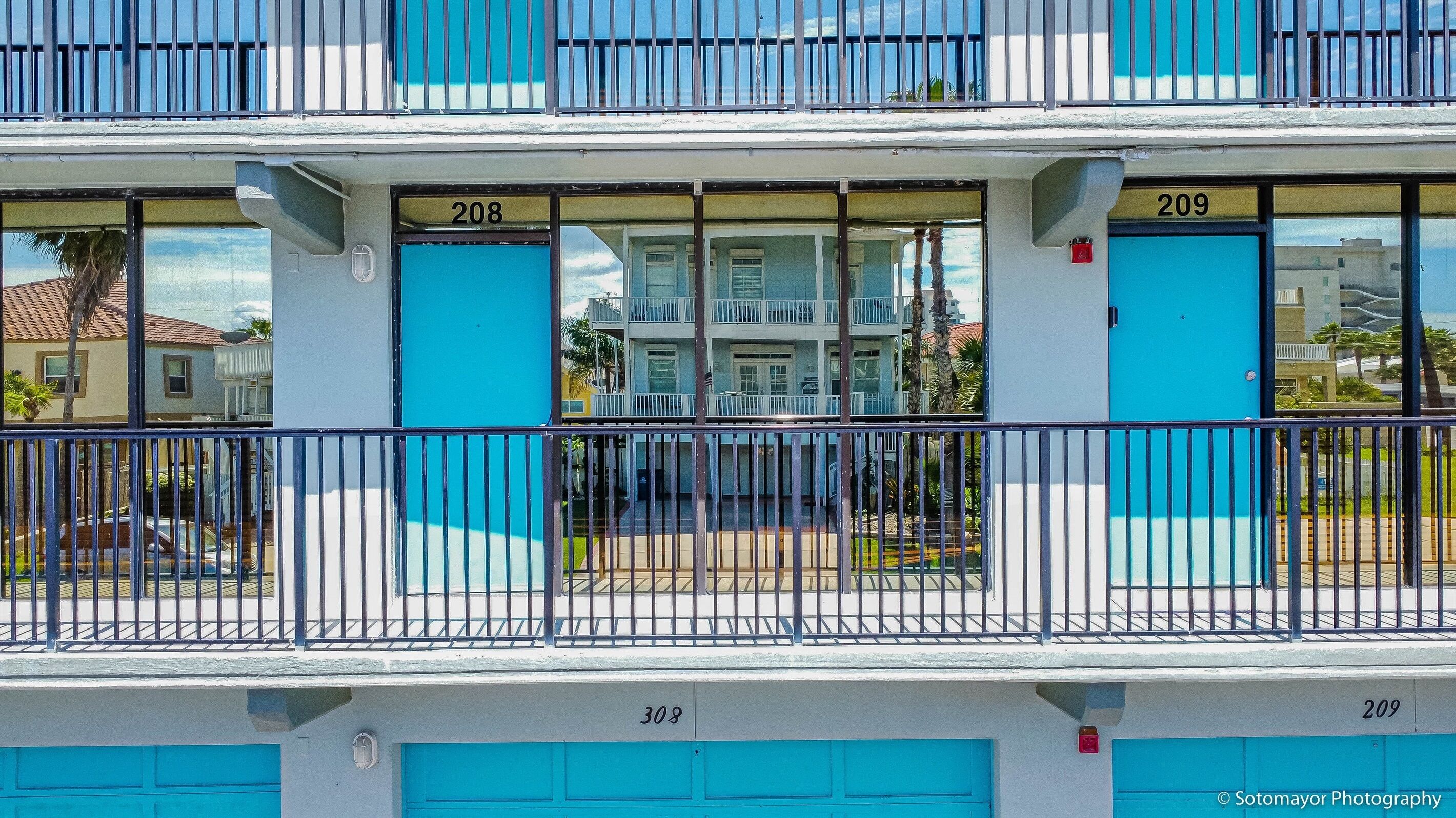 A multi-story building with numbered doors, balconies, and a visible garage area.