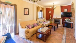 Una sala de estar con un sofá, una mesa de centro, una chimenea y un televisor.