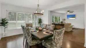 A dining area with a round table, patterned chairs, and a chandelier. - Spacious Ranch Home w/ Large Yard and Wi-Fi (Tampa)