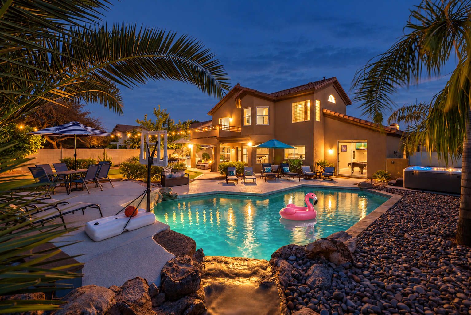 A residential property with a swimming pool, outdoor seating, and a well-lit patio area.