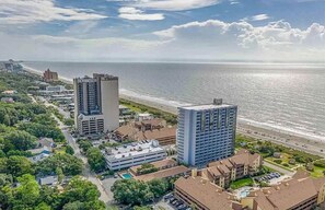 A coastal hotel with multiple high-rise buildings, a beachfront, and a parking area. - Direct Oceanfront Condo w/ Balcony - King Bed - Pool - Hot Tub - Myrtle Beach (Myrtle Beach)