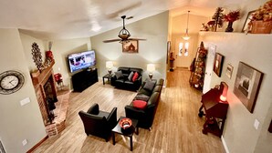 A spacious living room with a fireplace, a television, and a dining area. - Unwind and Relax at Hidden Trails Retreat (Payson)