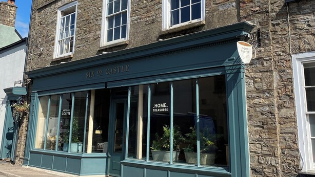 A two-story stone building with a sign reading "SIX ON CASTLE" and "HOME TREASURES". - Six on Castle (Tiverton)