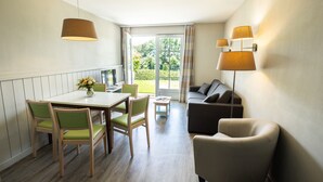 Un espacio habitable pequeño con comedor, un sofá y una lámpara.