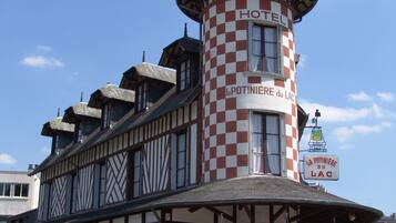 Een hotel met een opvallende toren en een bord waarop staat: HOTEL La POTINIERE du LAC.