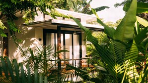 A modern house with a balcony, surrounded by lush tropical vegetation. - La Prometida Hotel (Cahuita)