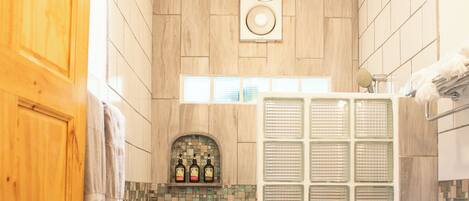 A bathroom with a wooden door, a shower with a glass enclosure, and a toilet.