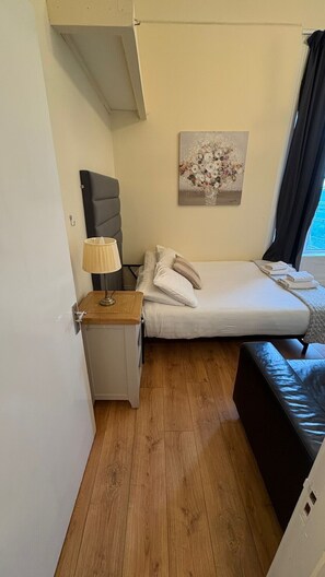 Tabla de planchar con plancha, cuna de viaje y ropa de cama