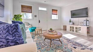 Una sala de estar con un sofá, una mesa de centro, un televisor y un mueble.