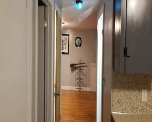 Enter a cozy space with a kitchen area and a hallway leading to a room.