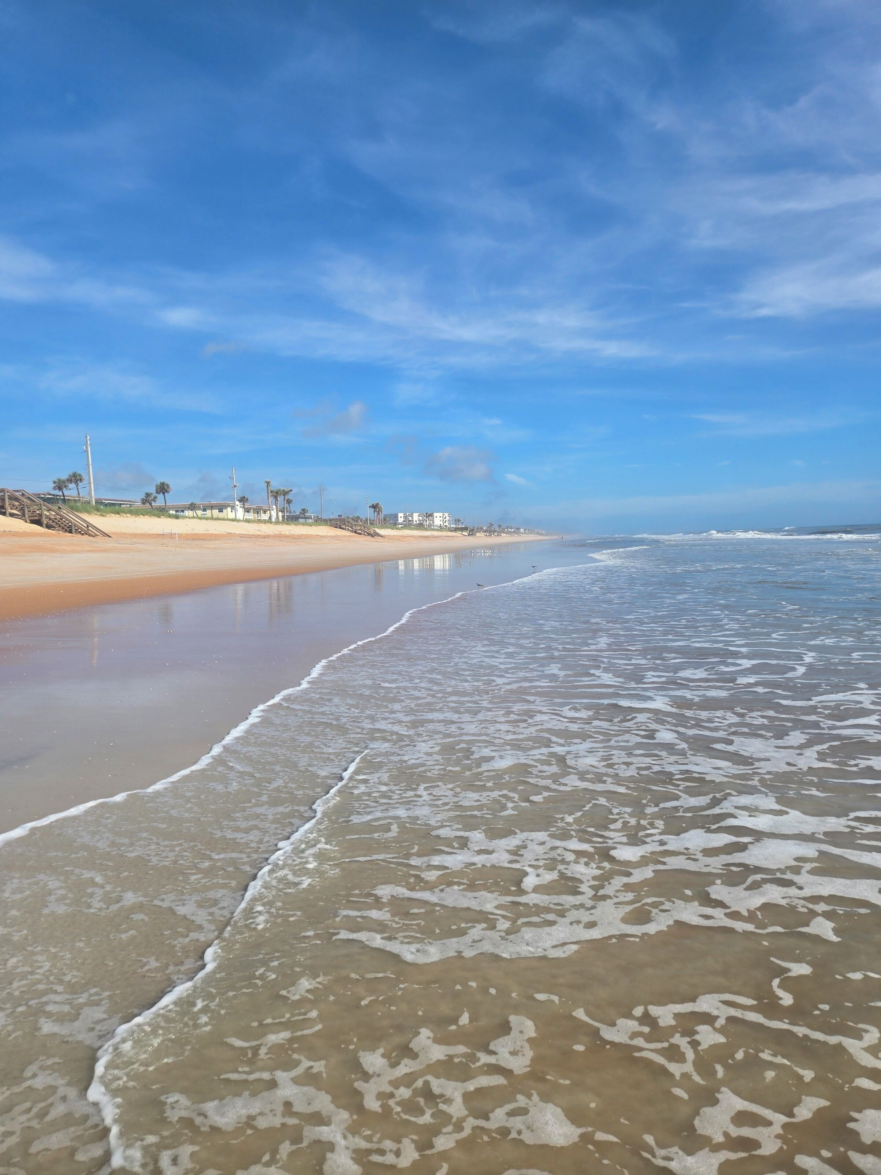 Une plage avec un rivage sablonneux et des vagues douces.