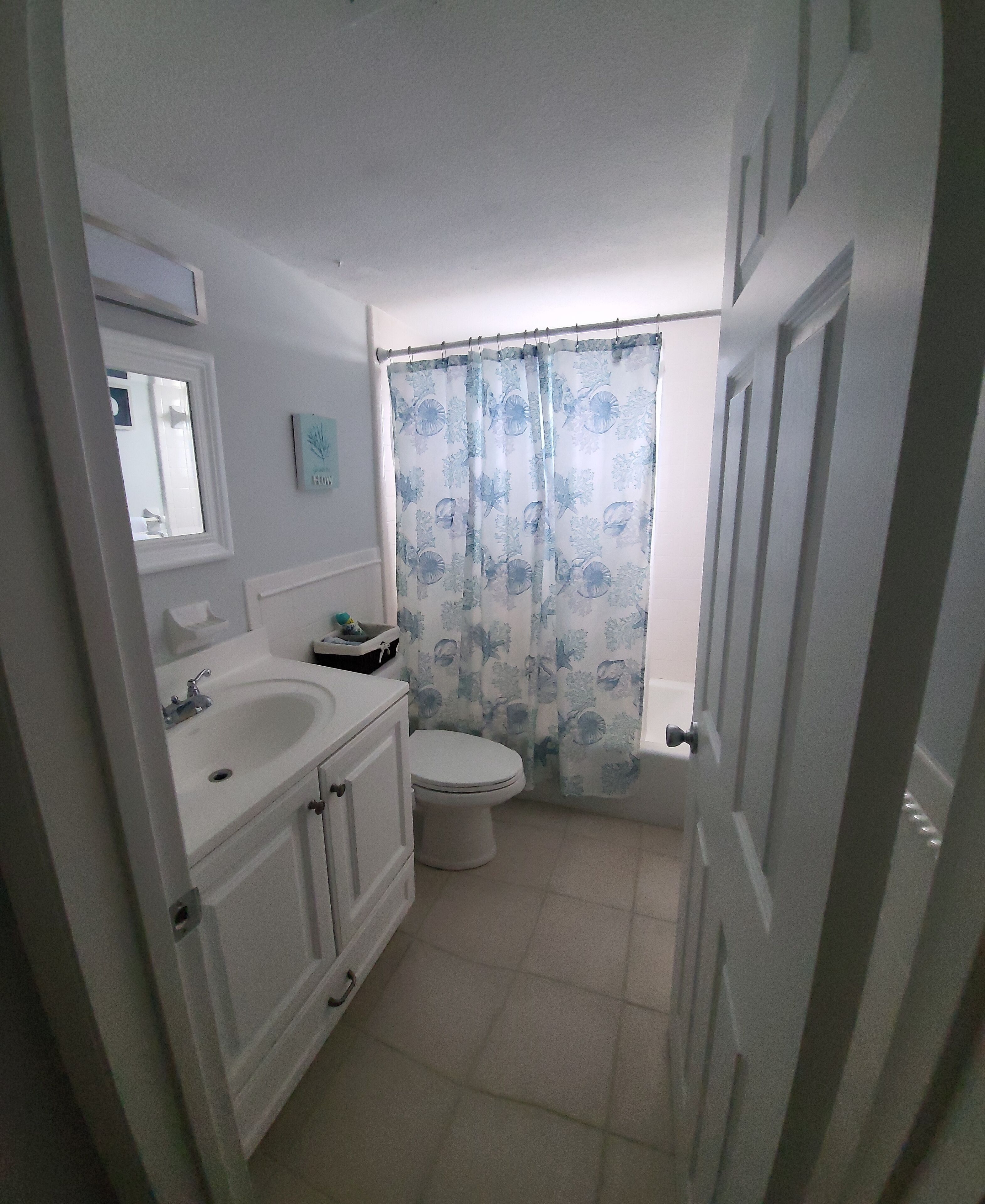 A bathroom with a toilet, sink, and cabinet.