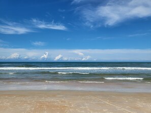 A beach with a clear sky and ocean waves.