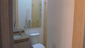 A small bathroom with a sink, toilet, and a mirror. - Zehn House in Girardot (Ricaurte)