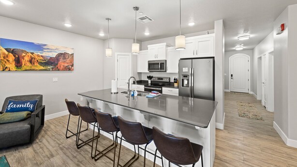 A modern kitchen with a central island, stainless steel appliances, and pendant lighting. - Bike, Hike, Swim, Explore 5 Star Resort - Guaranteed FUN & Memories (St. George)