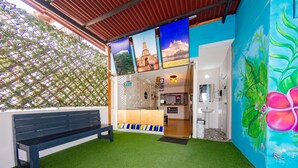A reception area with a bench, a reception desk, and a wall with a colorful mural.